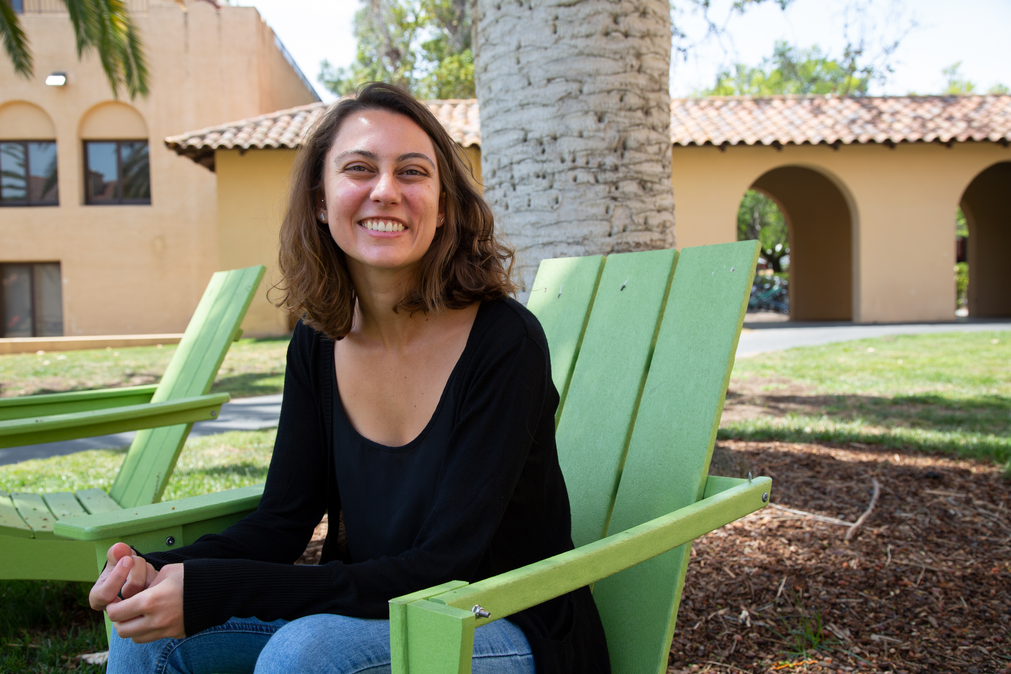 Photo of Gabriela Fiore Bonicio sitting on a green chair under a palm in Old Union square