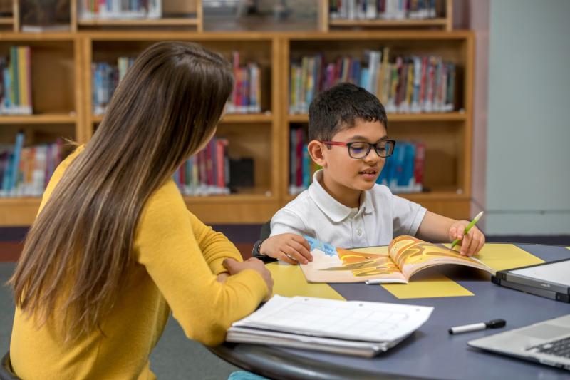 A tutor sitting with a young reader