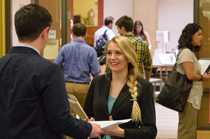 A GSE student (center) spoke with a potential employer on March 11 at a Stanford EdCareers job fair.