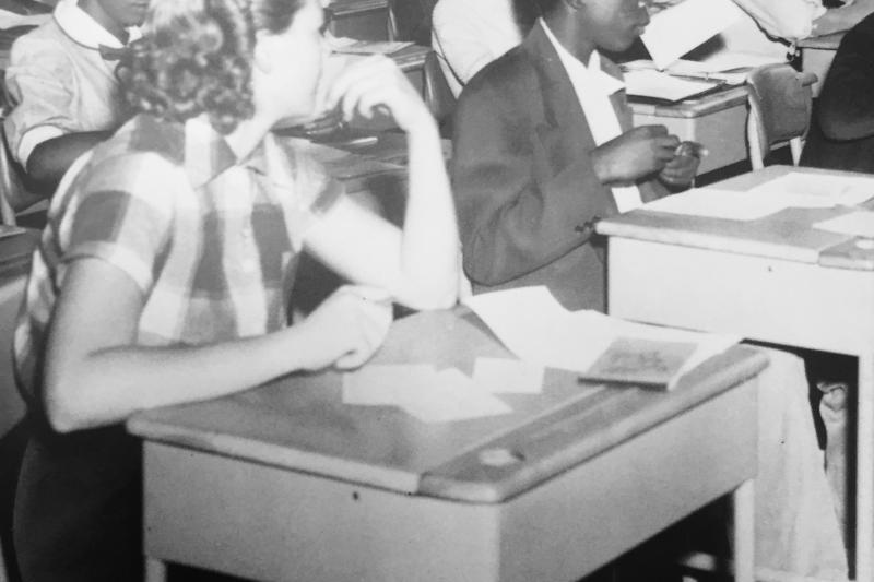 Old photograph of white and black children in a classroom.