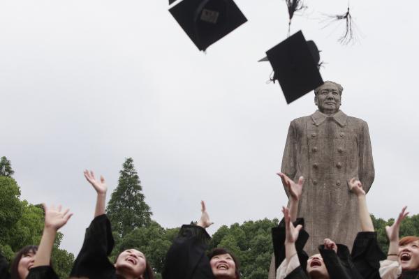 Graduates from Fudan University in Shanghai celebrate in front of the statue of late Chinese leader Mao Zedong on June 28, 2013.  Photo credit: Reuters