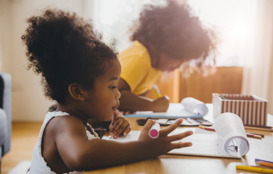 Photo of two children doing schoolwork at home