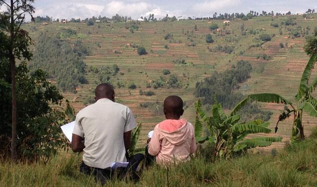 A young student takes a reading assessment in the hills of the Gicumbi district in rural Rwanda (Photo by Elliott Friedlander)