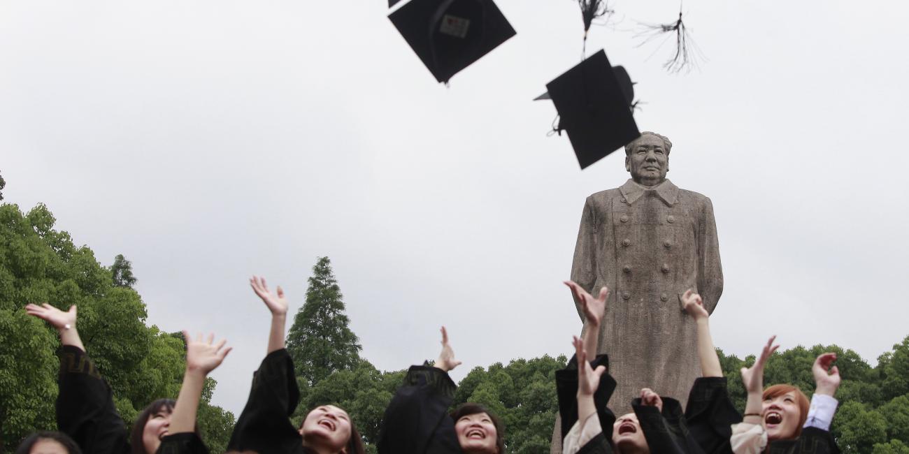 Graduates from Fudan University in Shanghai celebrate in front of the statue of late Chinese leader Mao Zedong on June 28, 2013.  Photo credit: Reuters